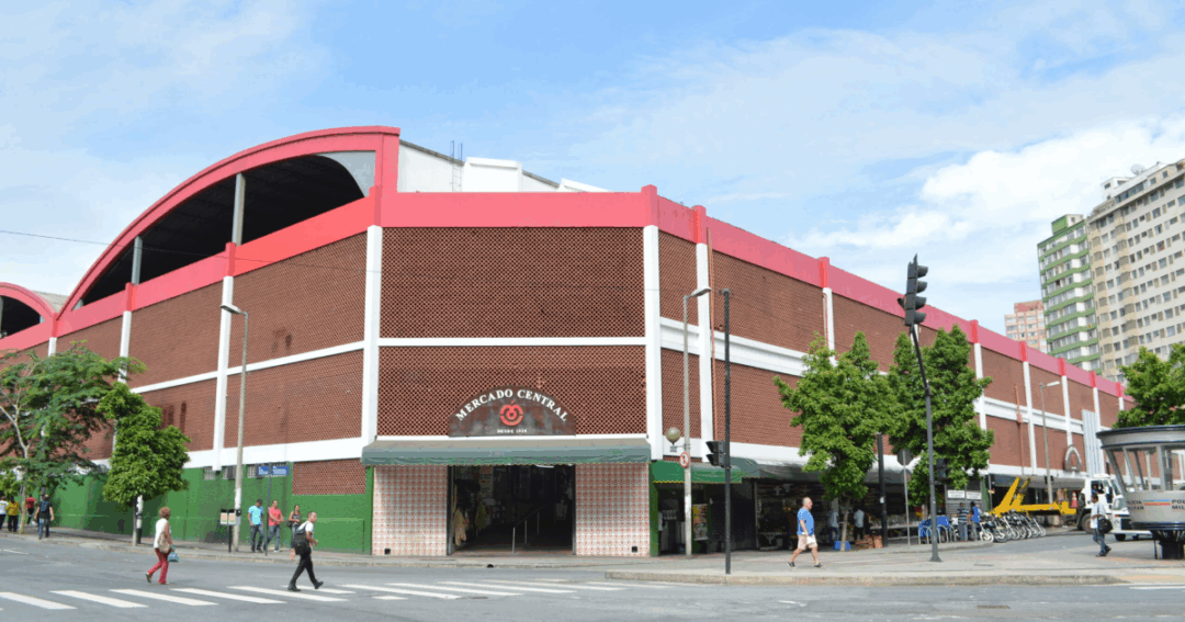 Fachada do Mercado Central de Belo Horizonte, com sua estrutura tradicional em vermelho e branco, ponto de encontro clássico para gastronomia, cultura e compras na cidade.