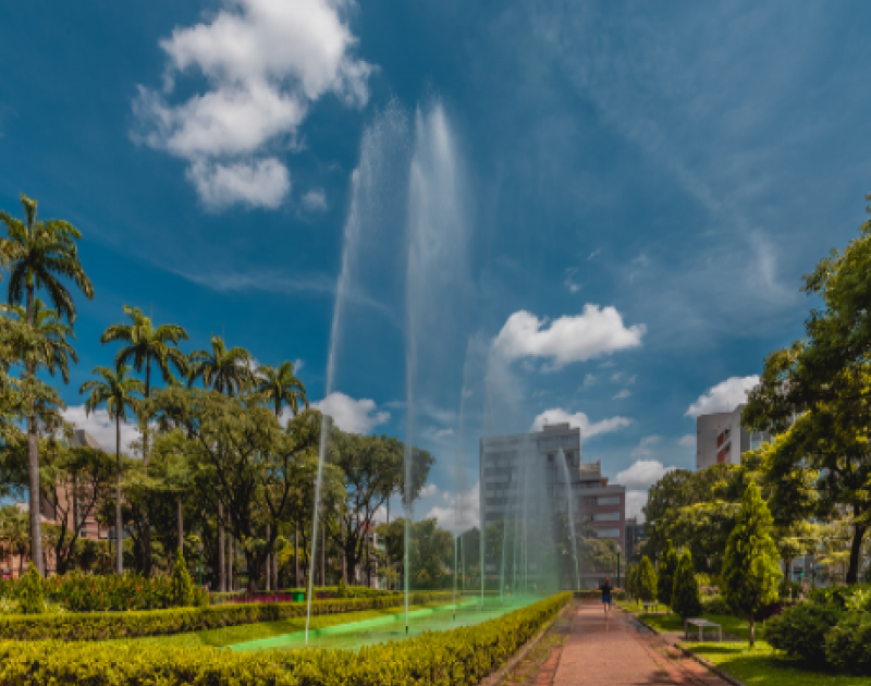Fonte e jardins da Praça da Liberdade em dia ensolarado.