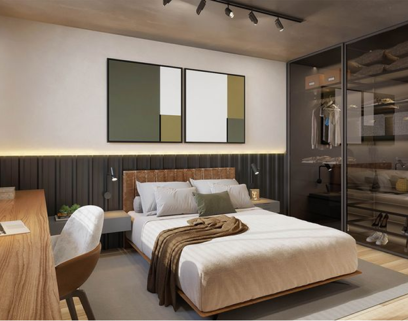 Quarto de casal com cama clara, cabeceira de na cor caramelo e armário planejado com portas abertas e iluminação embutida.