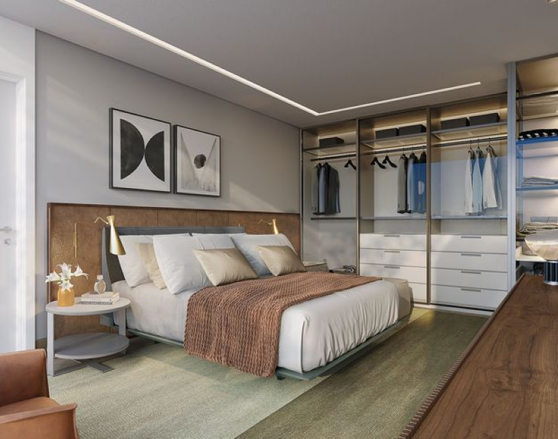 Quarto de casal com iluminação natural e decoração em tons terrosos e verdes, com armário de portas de vidro.