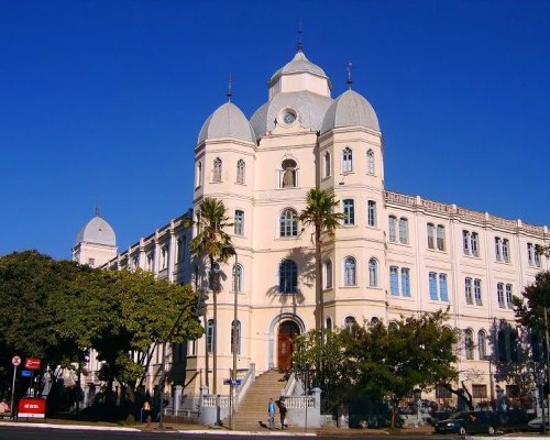  Fachada histórica do Colégio Arnaldo em Belo Horizonte, com arquitetura clássica e torres imponentes.